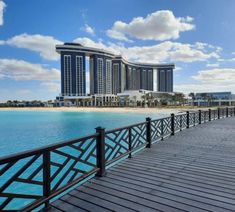 the boardwalk is next to some buildings and blue water