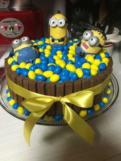 a birthday cake decorated to look like minion swimming in a tub with yellow and blue balloons