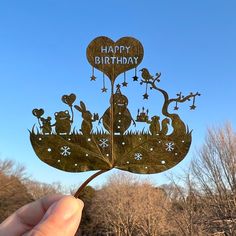 a person holding up a piece of paper with the words happy birthday on it