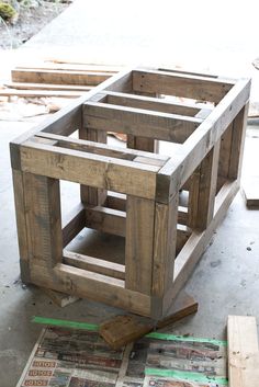 a wooden crate sitting on top of a floor next to some wood planks and plywood