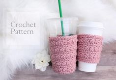 two crocheted coffee cups and a flower on a white fur rug with the words crochet pattern next to it