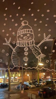 a snowman drawn on the window of a store