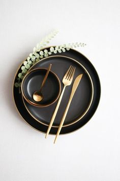 a black plate topped with two gold forks