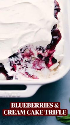 a white dish filled with whipped cream and berries