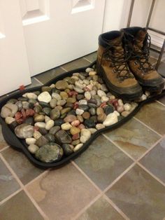 two pairs of hiking boots sitting on top of a pile of rocks in front of a door