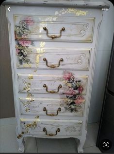 an old dresser with flowers painted on the drawers and gold handles is shown in this photo