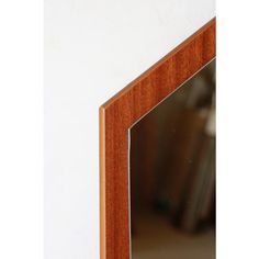 a wooden mirror hanging on the side of a wall