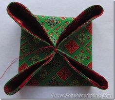 an origami box with red and green designs