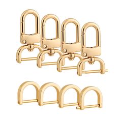 six pairs of brass - plated hooks on white background