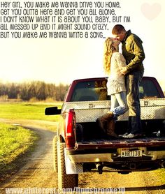 a man and woman kissing in the back of a pick up truck on a dirt road