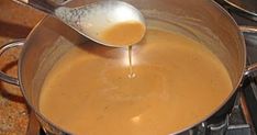 a spoon is being used to stir food in a saucepan on the stove top