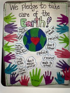 a bulletin board with handprints on it and the words we pledge to take care of the earth