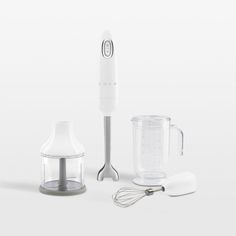 a blender, mixer and whisk on a white surface