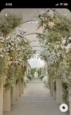 the walkway is lined with white flowers and greenery