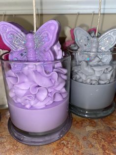 two candles with purple and silver decorations in them