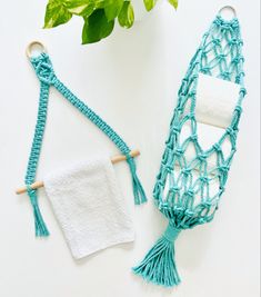 two pieces of crochet are next to a potted plant and towel holder