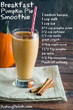 a glass filled with pumpkin pie smoothie next to cinnamon sticks