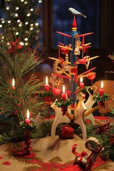 a christmas tree with lit candles and decorations