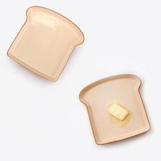 two slices of bread with butter on them sitting next to each other in front of a white background