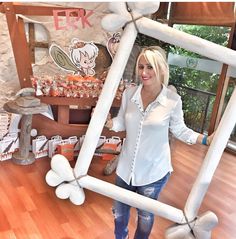 a woman standing in front of a large white balloon frame with balloons attached to it