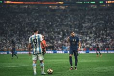 two soccer players are on the field during a game with an audience in the background