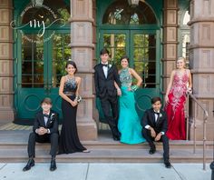 a group of young people standing next to each other in front of a green building