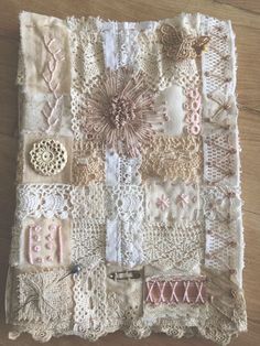 a close up of a piece of cloth on a wooden floor with lace and buttons