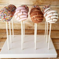 four different types of donuts on sticks with sprinkles and chocolate frosting