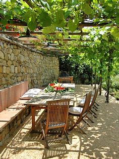 an outdoor table and chairs under a tree