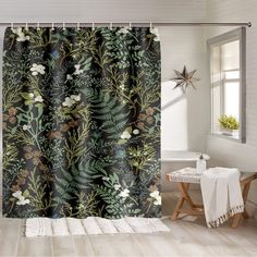 a bathroom with a shower curtain that has plants on it