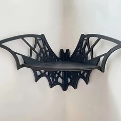 a metal bat shaped shelf on the wall