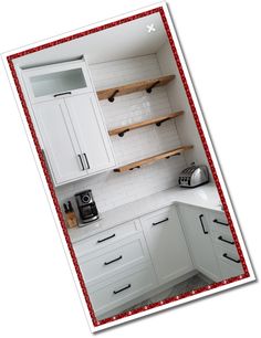 a kitchen with white cabinets and red border around the countertop, along with wooden shelves