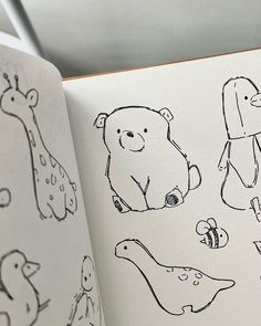 an open children's book with drawings of animals and birds in black ink on white paper