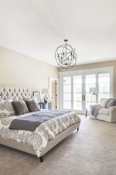 a large bed sitting in the middle of a living room next to a doorway with french doors