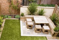 a small backyard with grass and brick walls