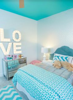 a bed room with a neatly made bed and a teddy bear