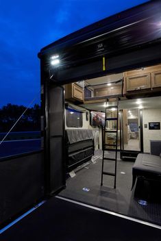 the interior of an rv with its door open at night time, and it is lit up