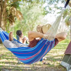 a man laying in a hammock with his feet up