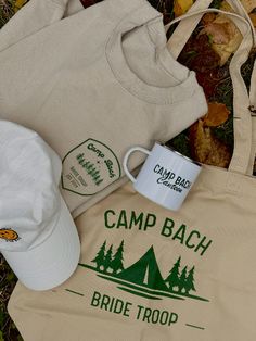 a coffee cup, tote bag, and cap sitting on the ground