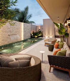 an outdoor living area with couches, chairs and a water feature in the center