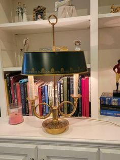 a lamp on top of a table next to books and figurines in a room