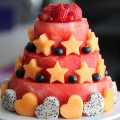 a watermelon cake decorated with fruit and stars