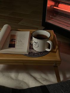 a cup of coffee and book on a tray