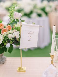 there is a table with flowers and a sign on it