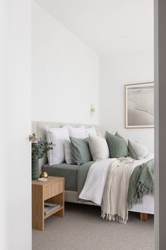 a bed sitting in the corner of a bedroom next to a table with a potted plant on it