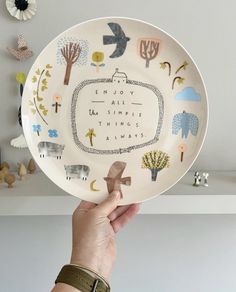 a person holding up a plate with the words enjoy all things always written on it