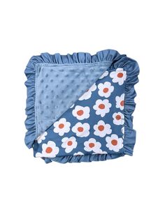 a blue blanket with white flowers on it and a red dot in the middle,