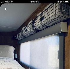 a bed sitting under a window next to a white pillow on top of a wooden floor