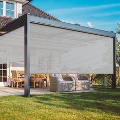 an outdoor covered patio area with furniture on the grass