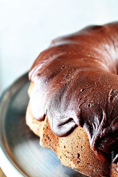 a bundt cake on a plate with chocolate frosting